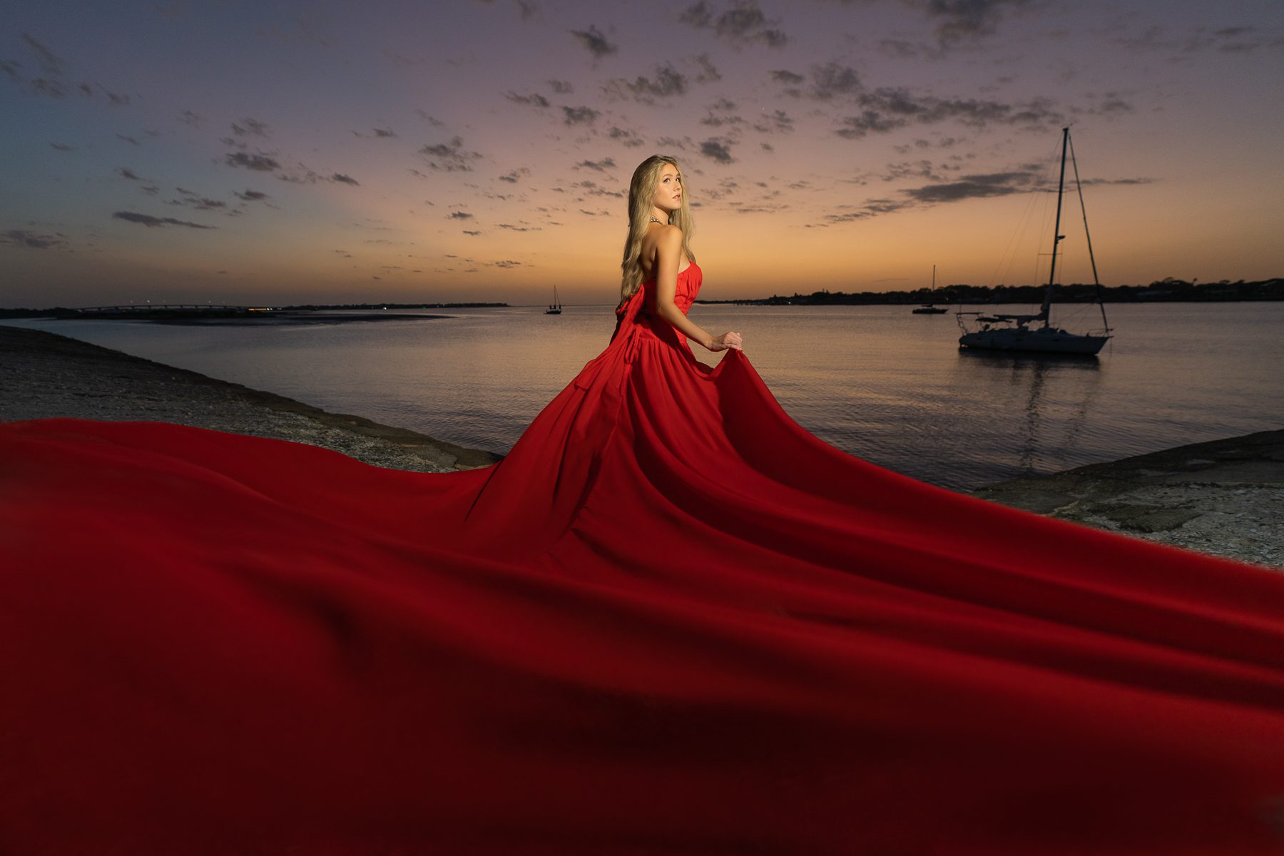 Strong woman in red dress in sunset