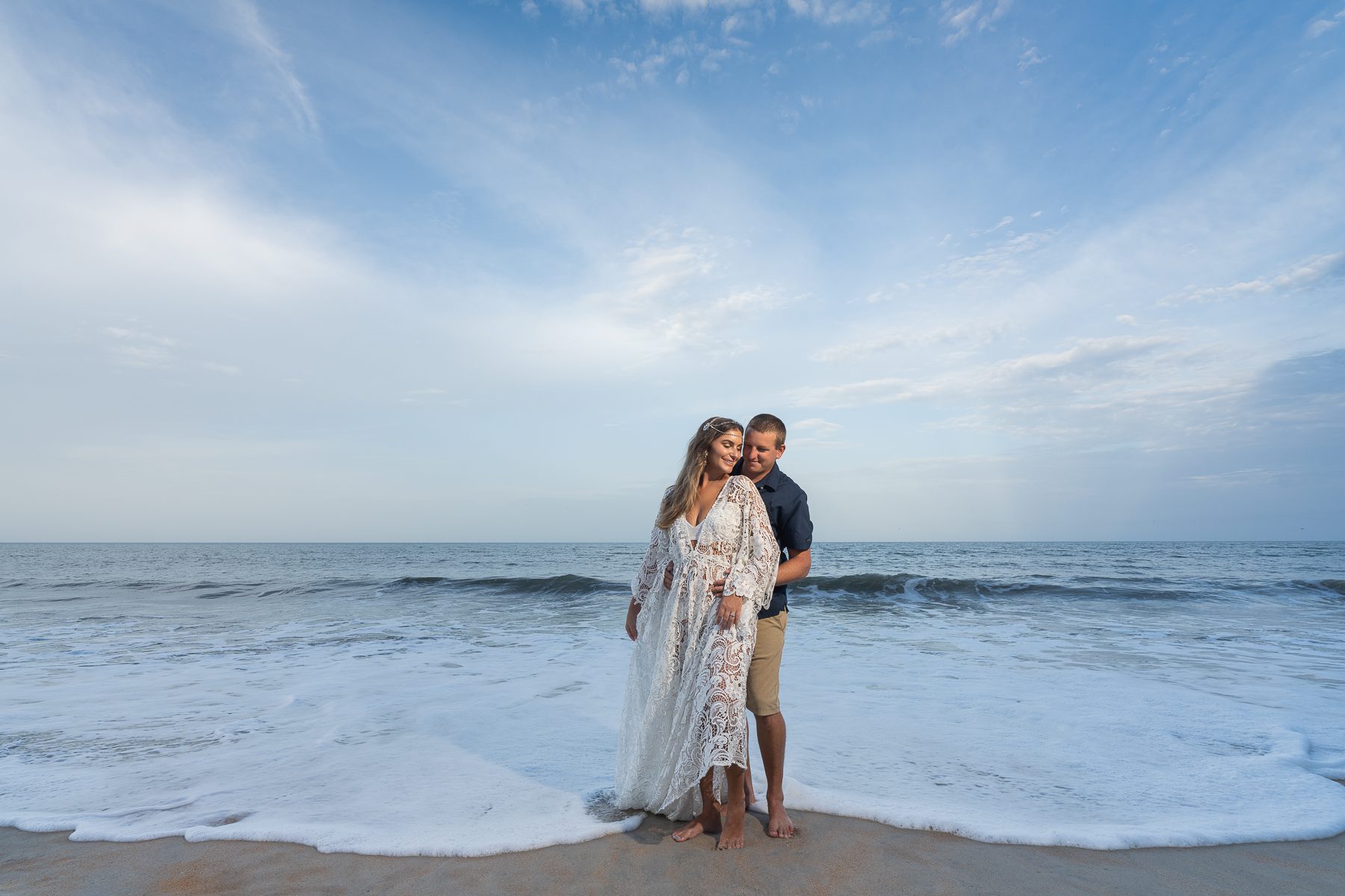Boudoir photo of girl in white lace dress with husband near sea 2